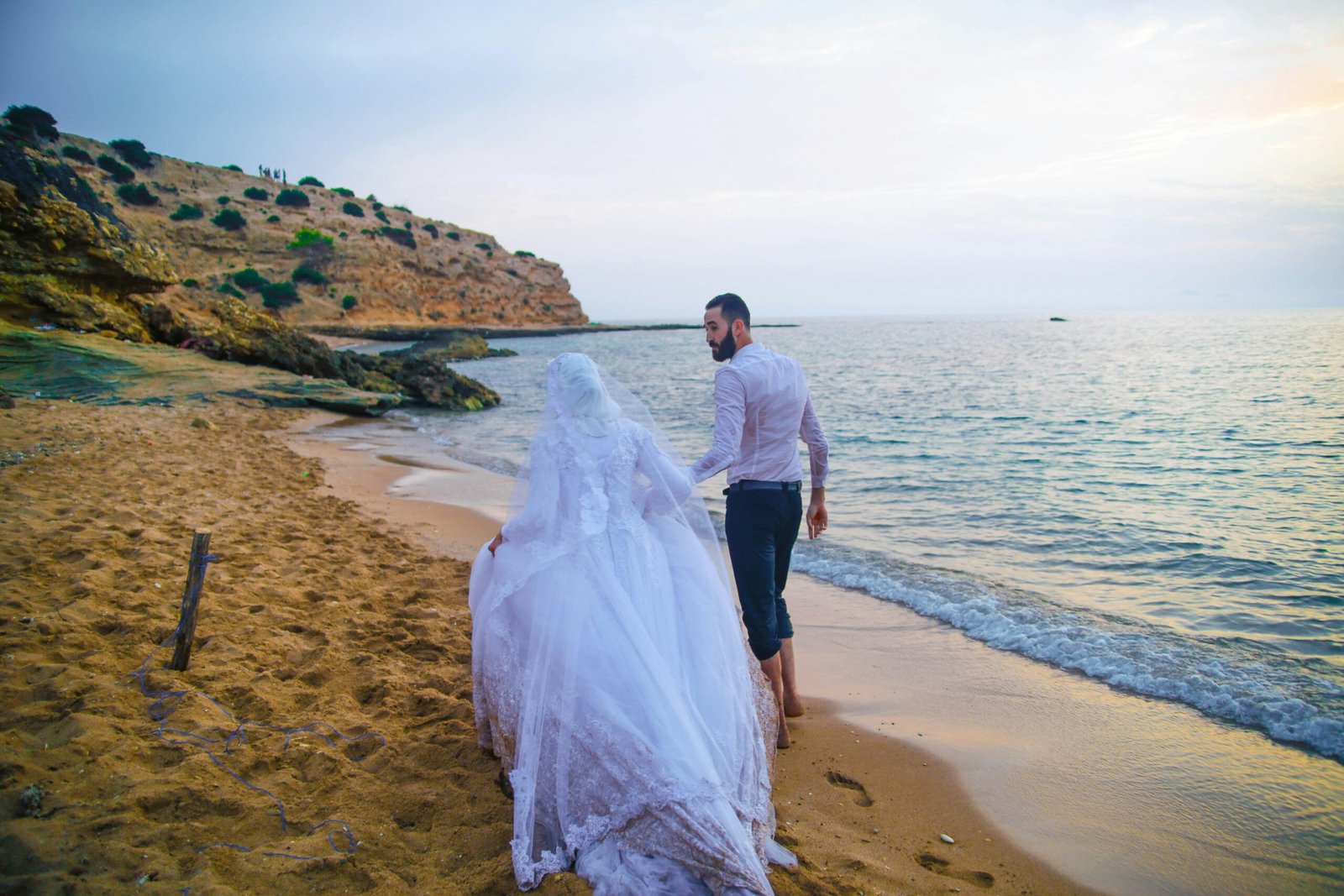 man and woman standing on beach during daytime